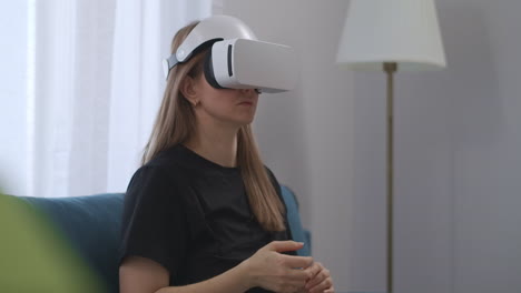 La-Mujer-Está-Usando-Una-Pantalla-HMD-Sentada-En-Casa,-Entretenimiento-Interactivo-Y-Educación-Con-Auriculares-Vr-Blancos-De-Tecnología-Moderna.